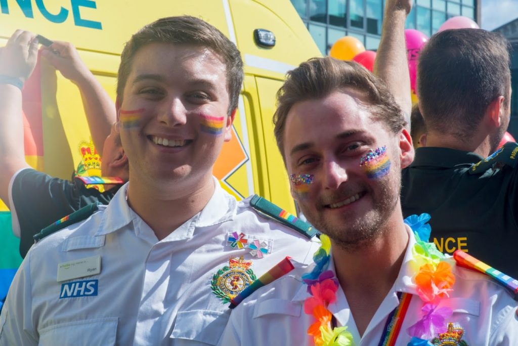 Two male staff smiling at PRIDE.