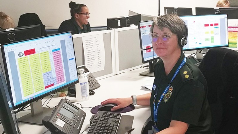 Paramedic sat at a desk with headset on