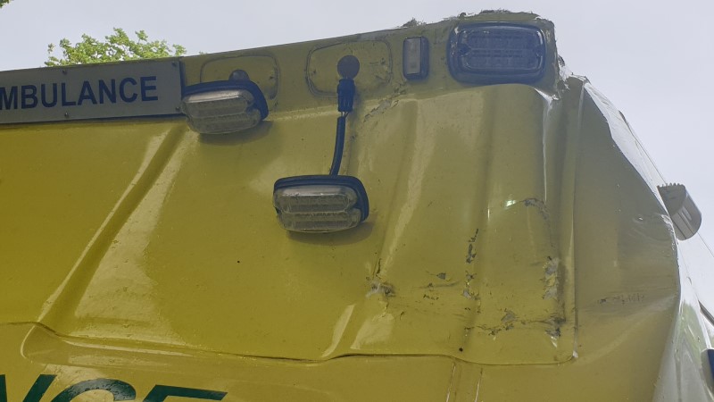 Extensive damage to the cab and emergency lights of an ambulance