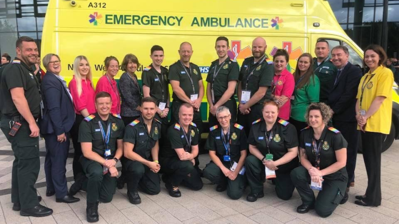 A group of frontline and corporate staff standing in front of an ambulance at the National Ambulance LGBT conference (2018)