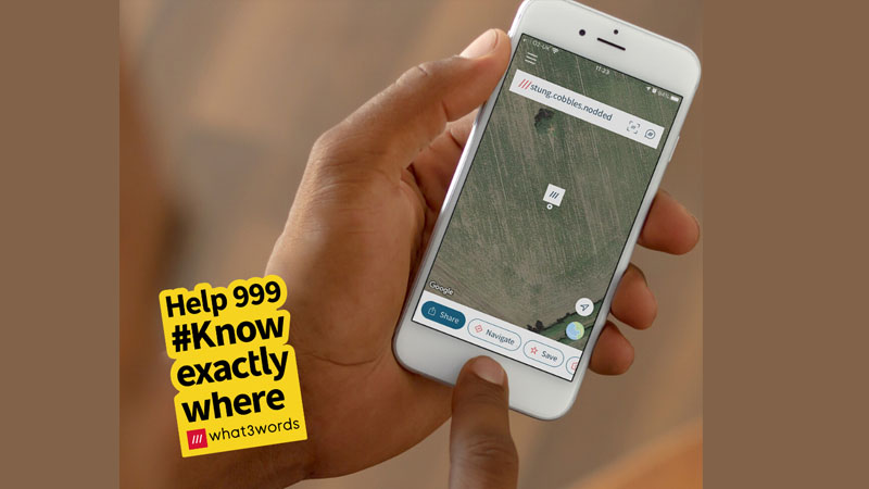Hand holing a phone with map co-ordinates using app, what3words
