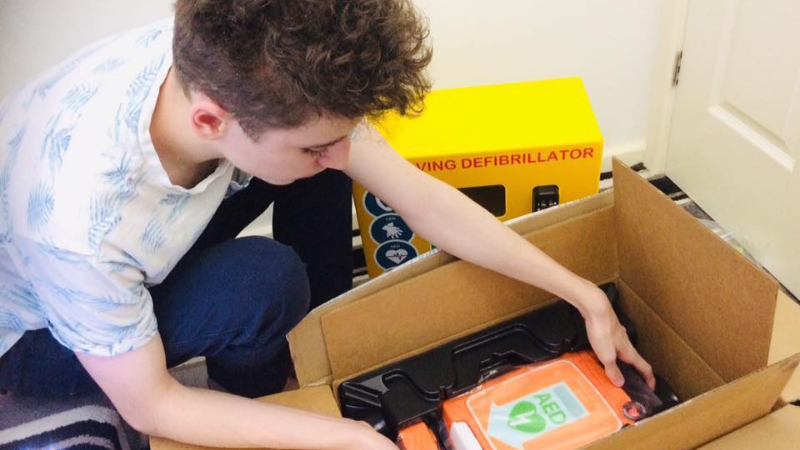 Person lifting defib from a box