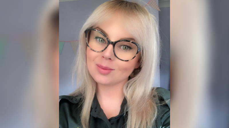 Blonde woman with brown glasses taking a selfie