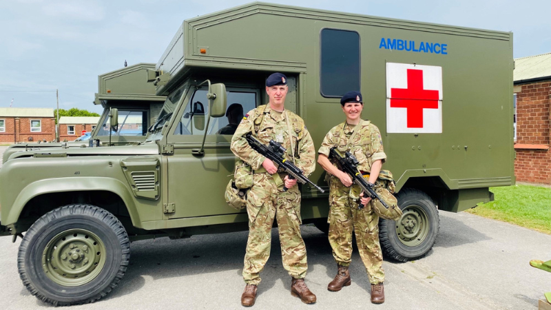 Dom and Rachel stood in front of an army ambulance