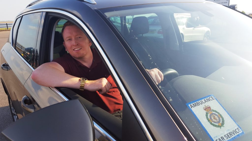 Male sat in a car.