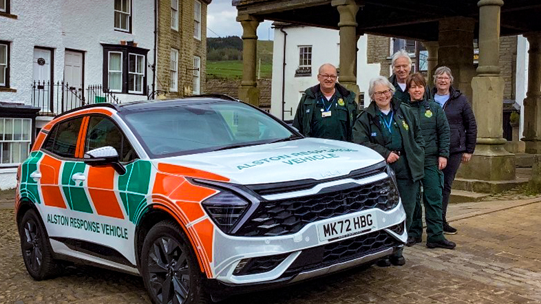 Alston response vehicle stood next to it are the five community EMTs. They are posing in Alston Town Centre.