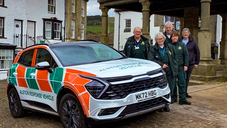 Alston response vehicle stood next to it are the five community EMTs. They are posing in Alston Town Centre.
