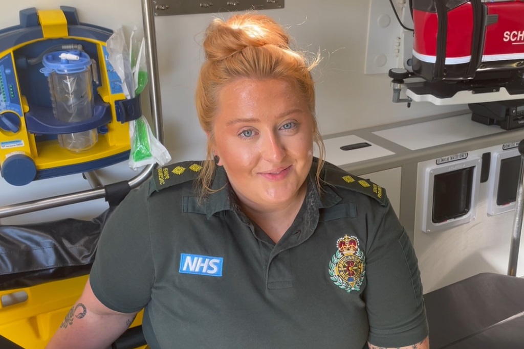 A female paramedic smiling in an ambulance