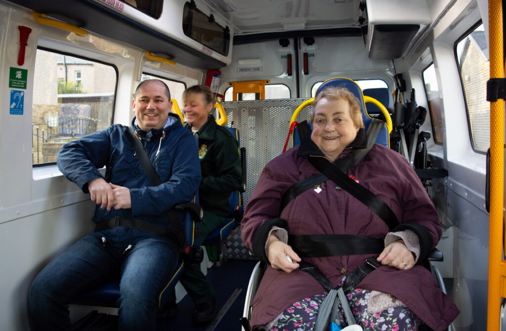People in an Patient Transport Vehicle smiling.