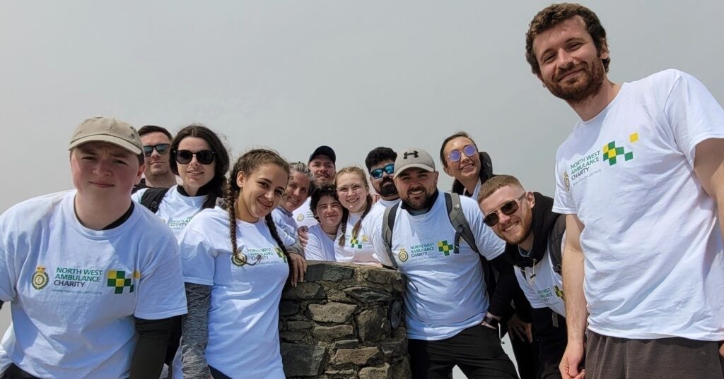 group of people wearing nwas charity fundraiser tops climbing up snowdon to raise money