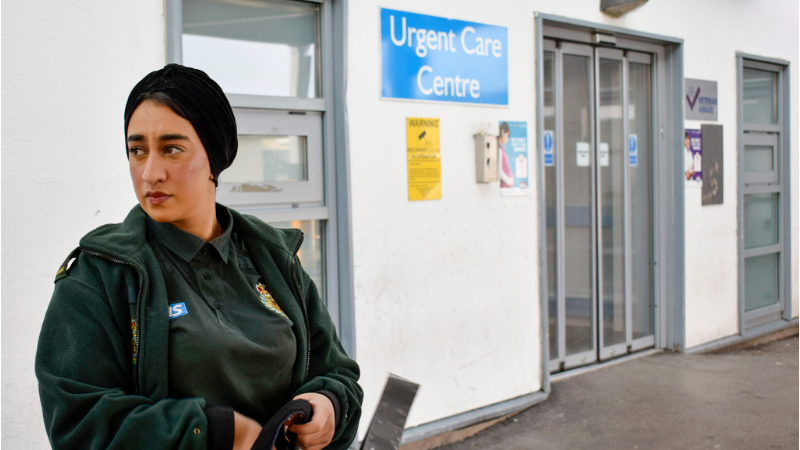 paramedic looking off camera outisde an emergency department