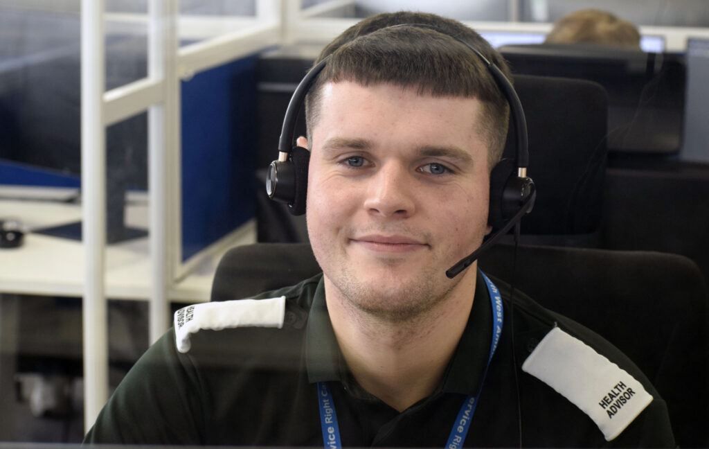 male health advisor wearing a headset and smiling