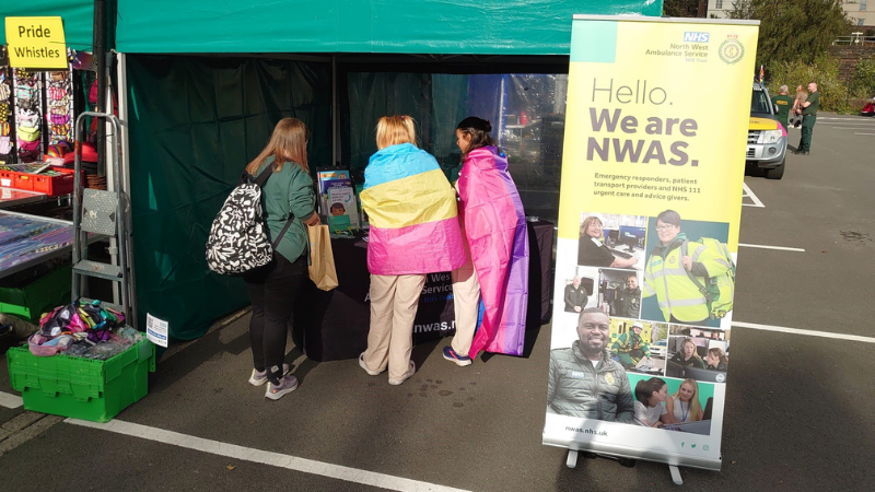 A green gazebo with three people in it with a pop up stand to the left which says: 'Hello we are NWAS'