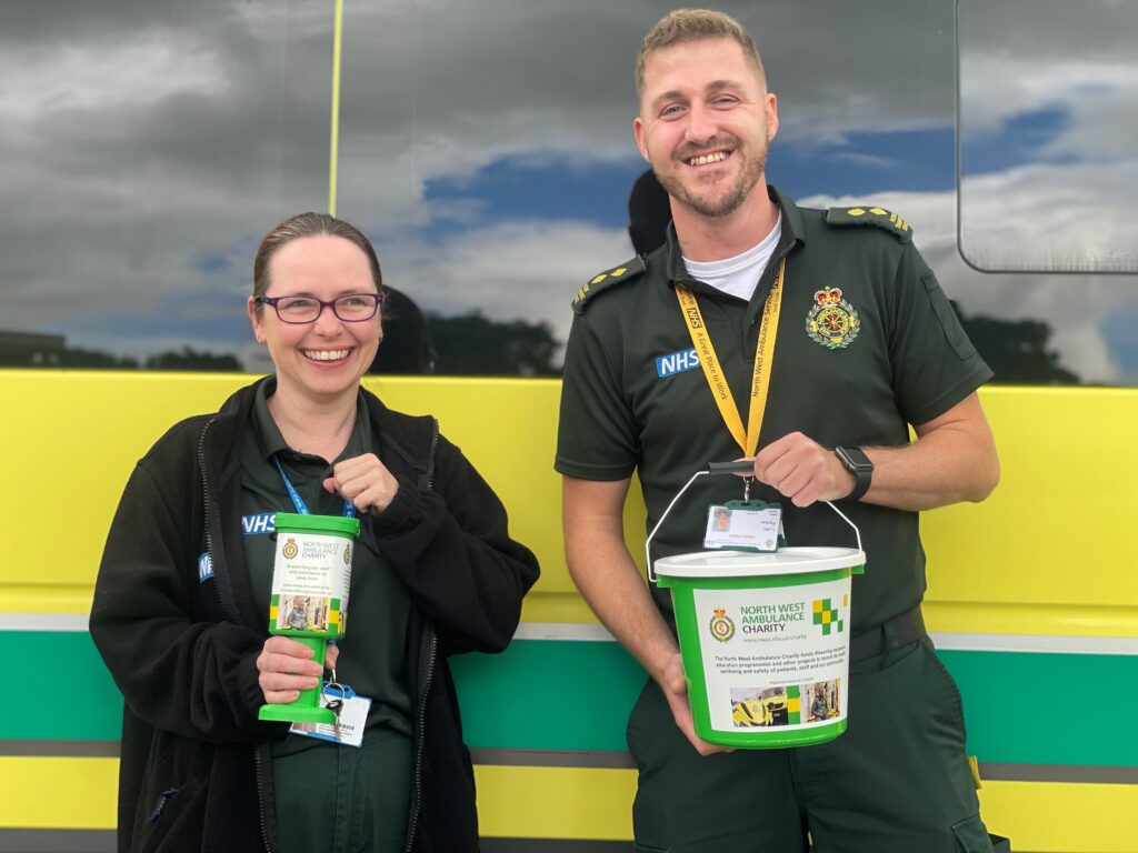 NWAS staff standing in front of an ambulance holding donation boxes