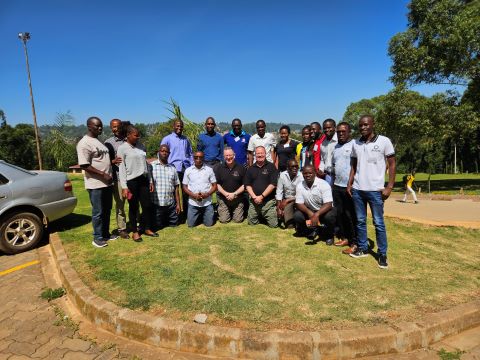 Group photo of multiple people in a sunny outdoor setting.