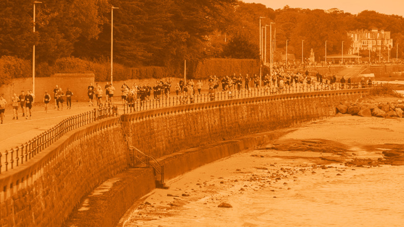 Group of runners running along the coast