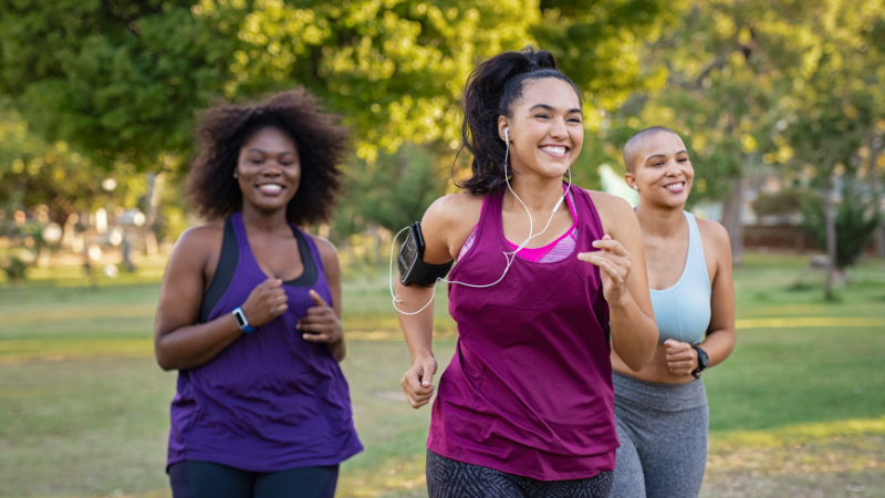 three women running around a park