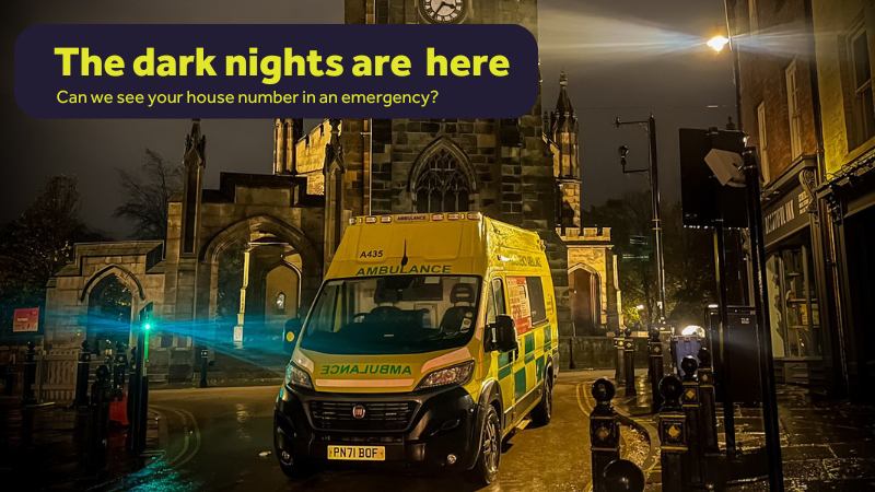 an ambulance parked outside of a clock tower at night with a text box above saying 'Dark nights are here'