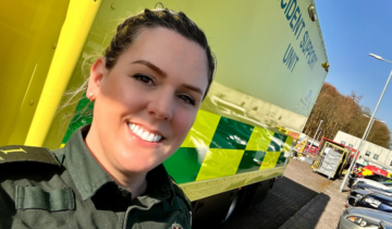 Megan stood in front of a stationary ambulance.