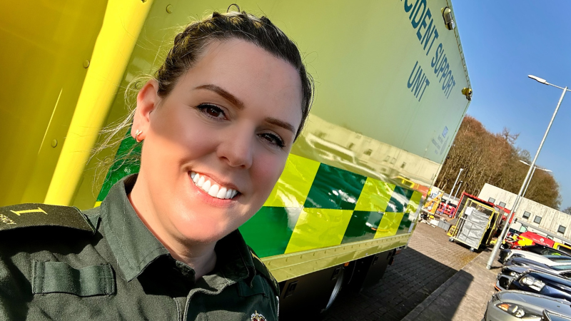 Megan stood in front of a stationary ambulance.