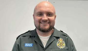 ambulance staff member in uniform smiling at camera