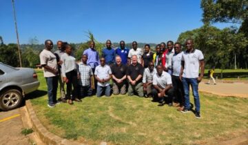 Group photo of multiple people in a sunny outdoor setting.