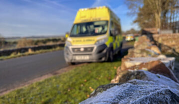Frost covered wall in front of a blurred out ambulance