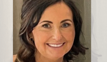 Head shot of a woman smiling. she has brown hair.