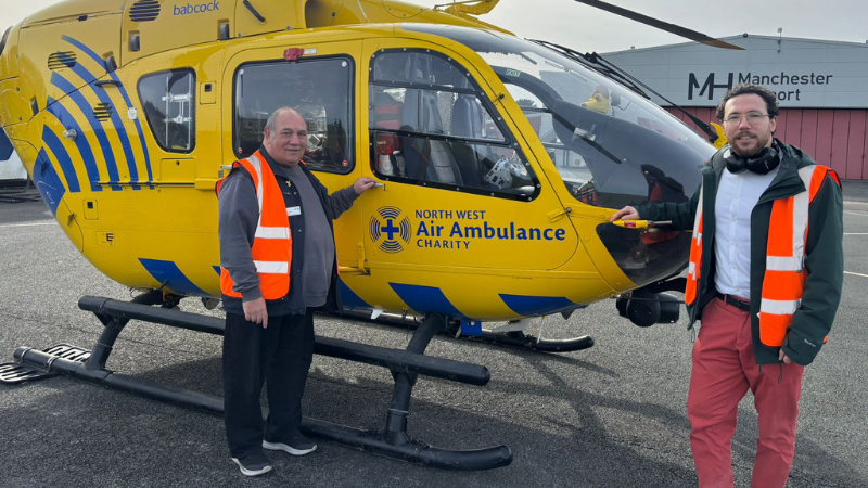 Volunteers stood next to an air ambulance wearing orange high vis vests.