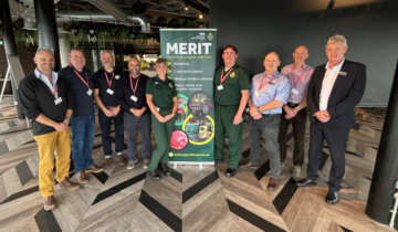 A group of emeregncy reponse staff stand togther for a picture next to a MERIT team banner.