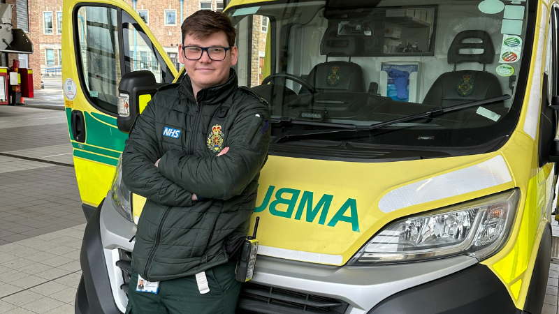 Newly Qualified Paramedic Matt stood in front of an ambulance.