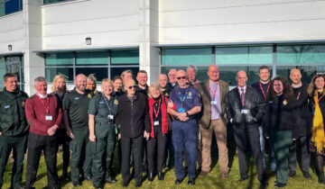 Ray Hughes and his wife Ann and friend Greg Wood pictured centrally surrounded by friends, family and ambulance staff.