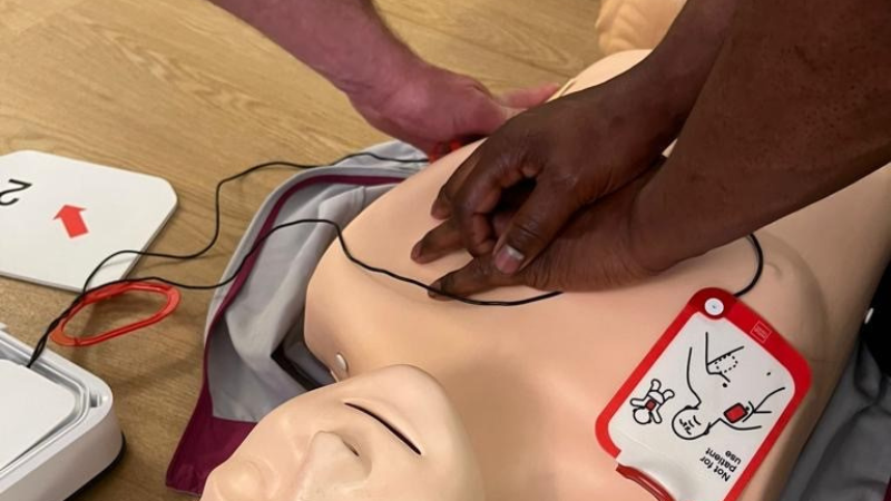 Hands on a manikin learning how to do CPR.