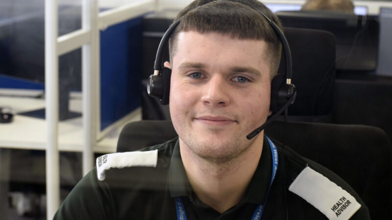 male health advisor wearing a headset and smiling